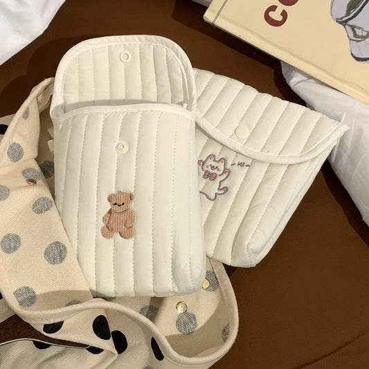 Baby bib with teddy bear design on a brown surface