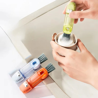 Set of three cleaning brushes with different colored handles held by a hand.